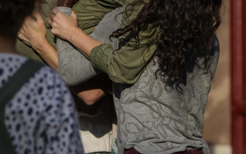 Katy ist eine weiße Frau mit langen, braunen Haaren, die ihr über den Rücken fallen. Sie trägt einen olivgrünen, langärmeligen Jumpsuit. Ihr Kopf ist nach hinten geneigt und sie singt energisch in ein Mikrofon, das sie in der rechten Hand hält, während sie auf den Schultern von drei anderen Tänzern getragen wird. Im Hintergrund ist die Wand eines sandsteinfarbenen Hauses zu sehen.