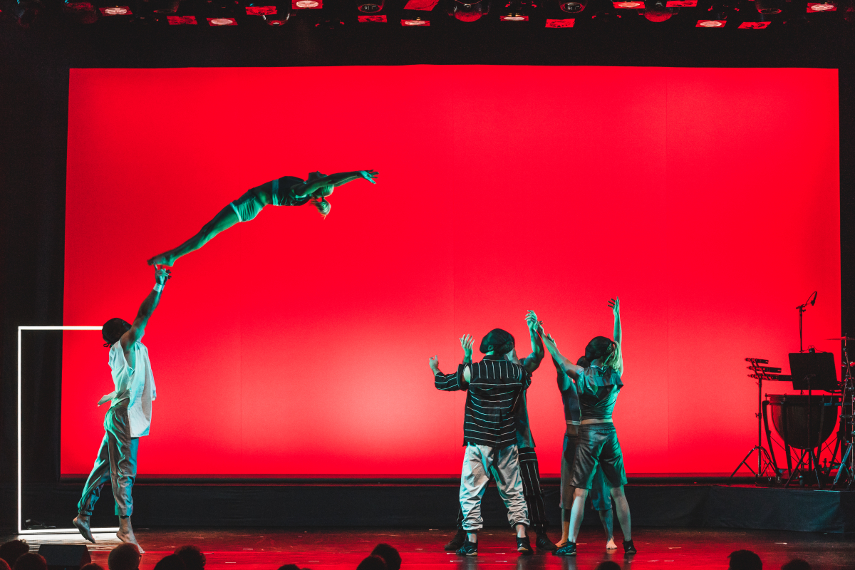 Chamäleon Theater © Koone Artistenensemble vor rotem Hintergrund